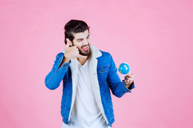 Man holding a globe and asking for a call