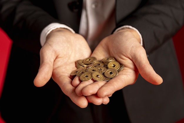 Man holding golden chinese coins in hands for chinese new year