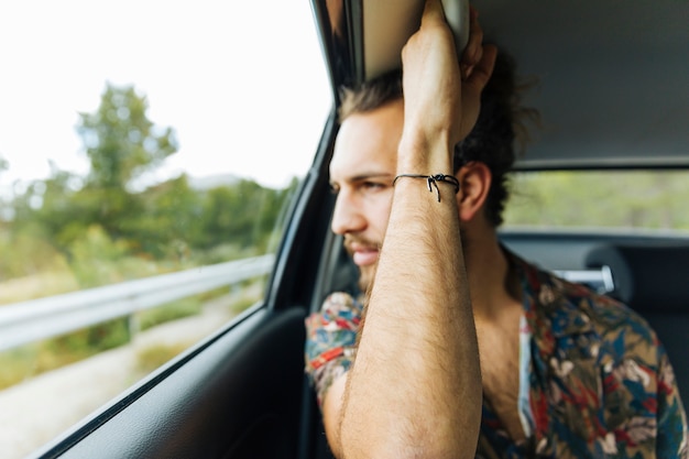 Free photo man holding handle in car