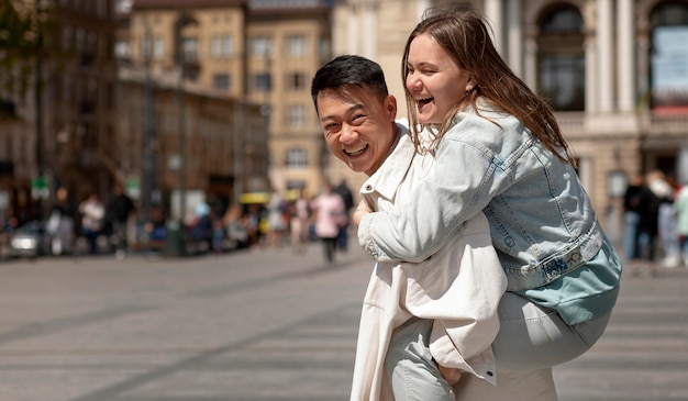 Free photo man holding happy woman on back