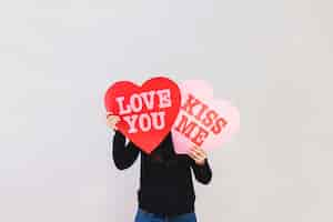 Free photo man holding hearts with messages of love