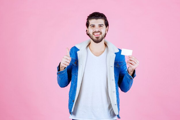 Man holding his business card and meaning his success