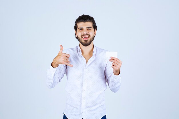 Man holding his business card and meaning his success