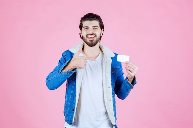 Man holding his business card and meaning his success