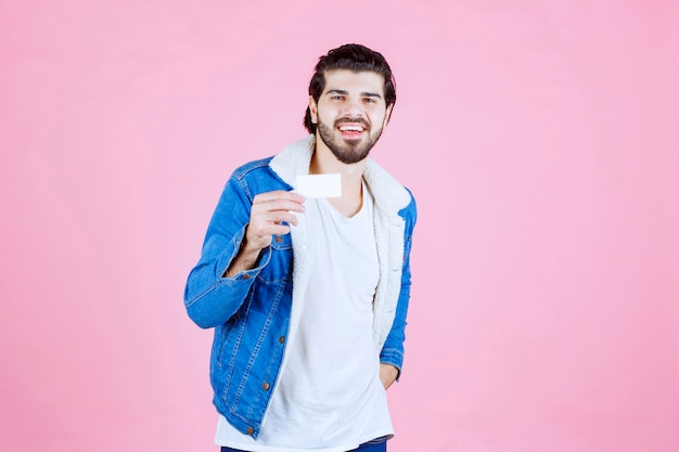 Man holding his business card and meaning his success