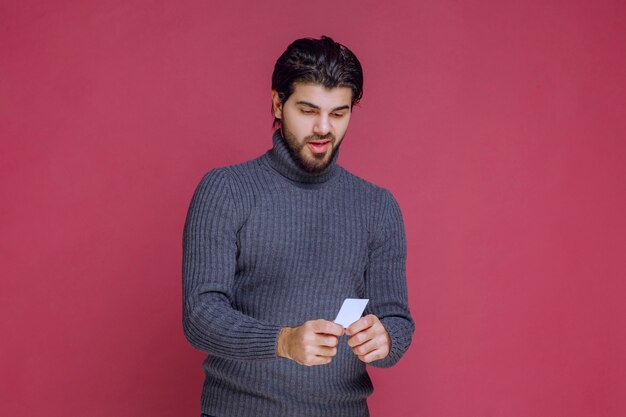 Man holding his business card, presenting or recieving it.