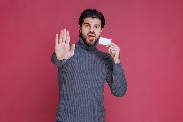 Man holding his business card and stopping someone.