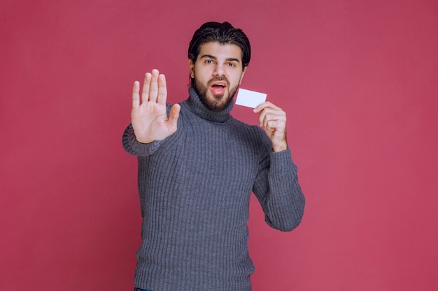 Man holding his business card and stopping someone.