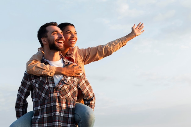 Man holding his girlfriend on his back with copy space