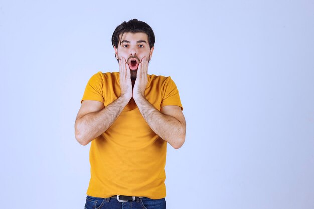 Man holding his head with both hands and looking excited.