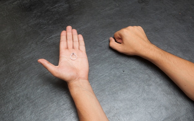 A man holding his one hand closed and other one open, hand guessing game