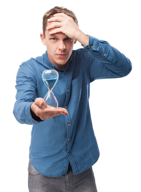 Man holding an hourglass with a hand on head