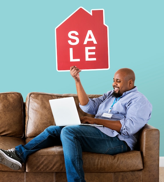 Man holding a house sale icon