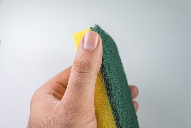 Man holding kitchen sponge on the white background