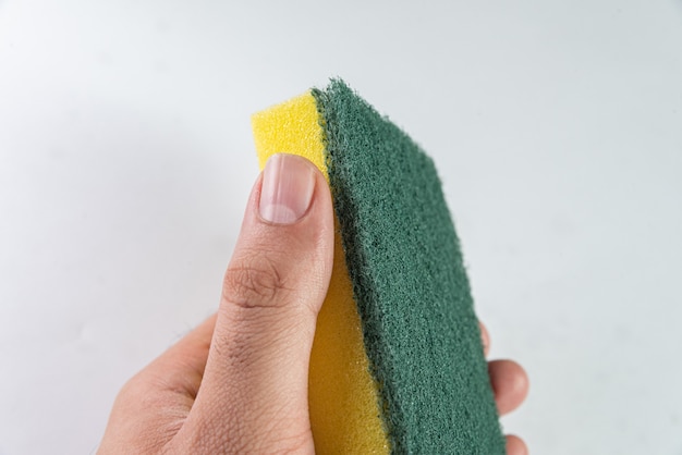 Man holding kitchen sponge on the white table