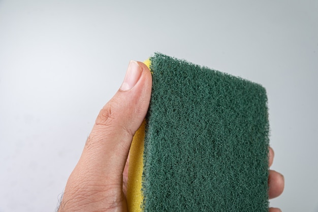 Man holding kitchen sponge on the white table