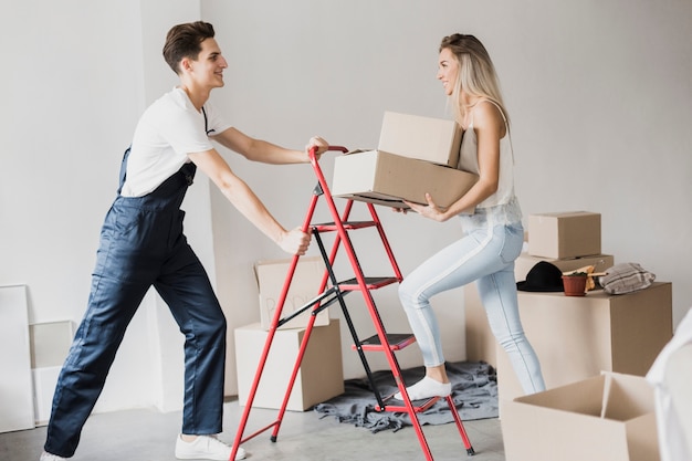 Man holding ladder for woman to climb