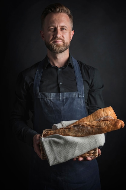 Free photo man holding loaves of bread
