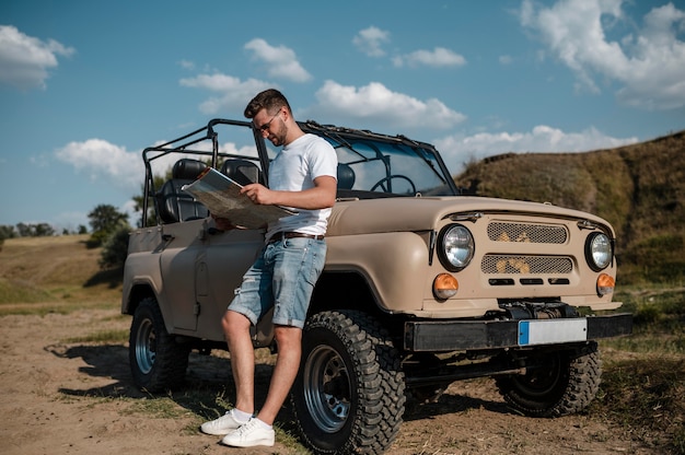 Free photo man holding map while traveling by car