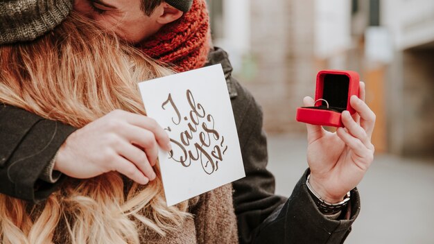 Man holding napkin and ring while embracing woman