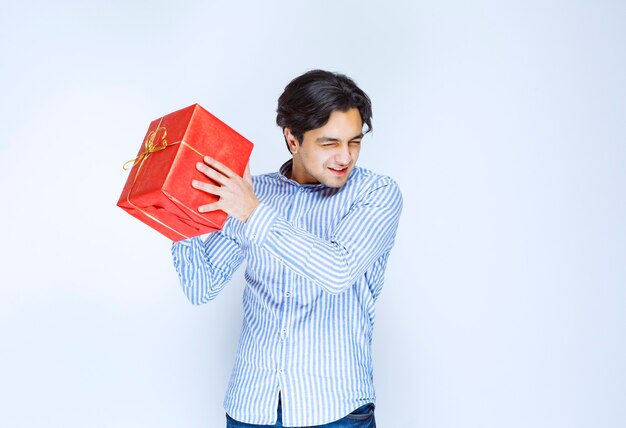 Man holding or offering a red gift box to his girlfriend. High quality photo