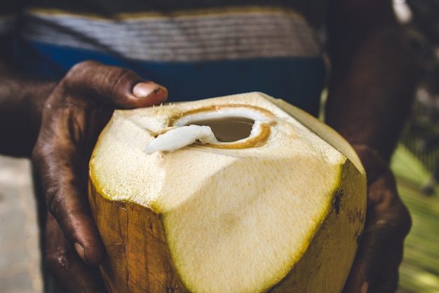 Man holding an open coconut