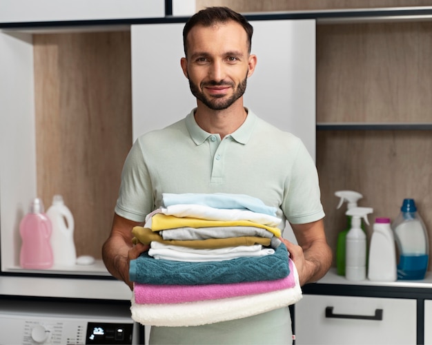 Man holding a pile of clean clothes