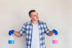 Free photo man holding pink and blue paint