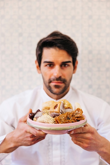 Free photo man holding plate of delicious arab food