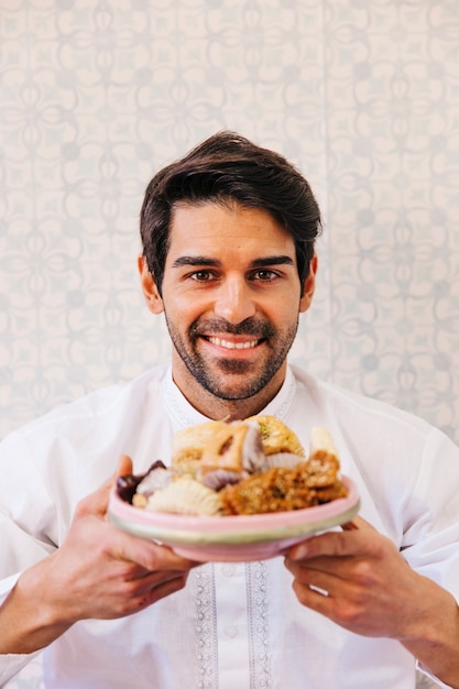 Man holding plate of delicious arab food