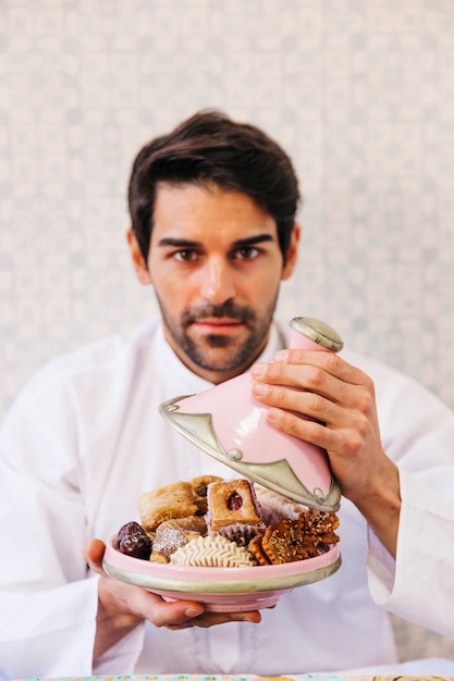 おいしいアラブの食べ物のプレートを持っている男