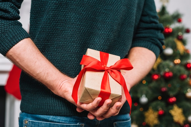 Man holding present behind back 