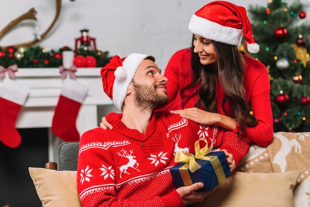 Man holding present box near woman 