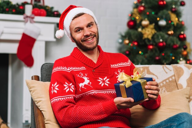 Man holding present box on sofa 