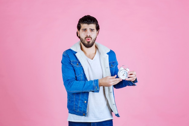 Man holding and promoting an alarm clock