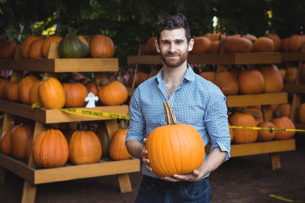 Foto gratuita zucca della tenuta dell'uomo al supermercato