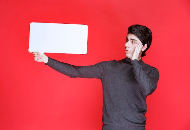 Man holding a rectangular ideaboard and brainstorming