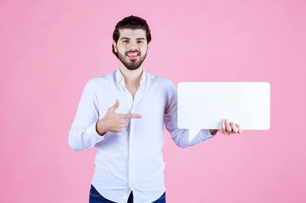Man holding a rectangular thinkboard and presenting it. 