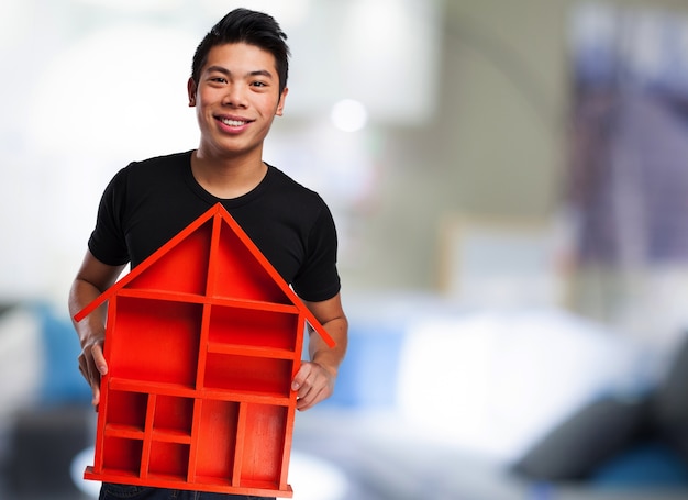 Free photo man holding a red house