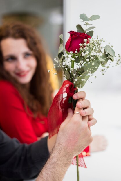 Man holding red rose branch in hand 