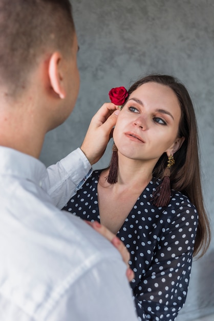 Free photo man holding rose at woman head