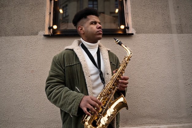 Man holding saxophone medium shot