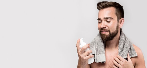 Man holding a shaving cream bottle with copy space