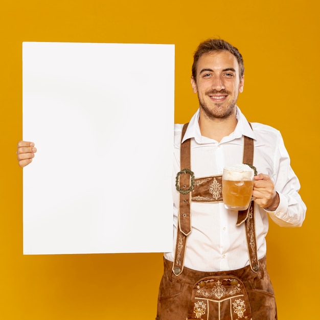 Free photo man holding sign mock-up and beer pint