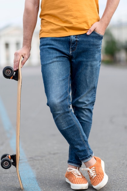 Man holding a skateboard front view