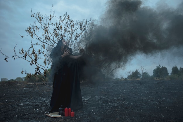 Man holding a skull in a black fog