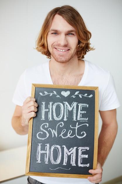 Free photo man holding a small blackboard