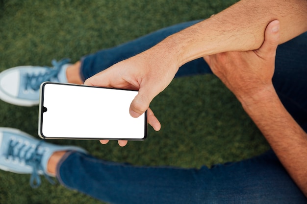 Free photo man holding smartphone with mock-up