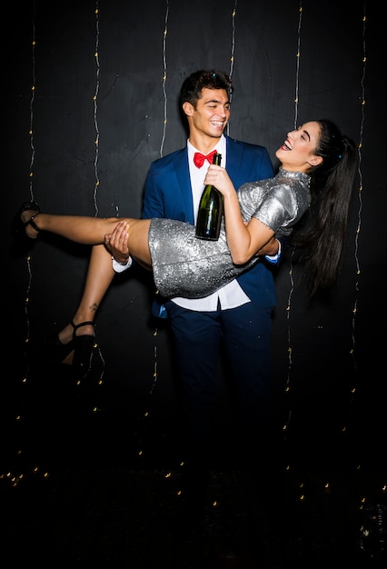 Man holding smiling woman with bottle 