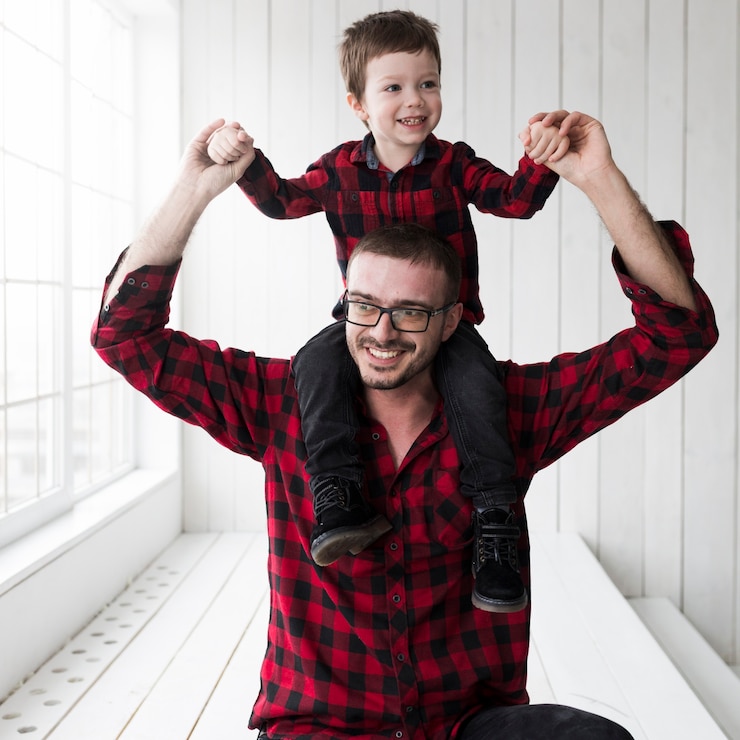 Free Photo man holding son on fathers day in front of chalkboard